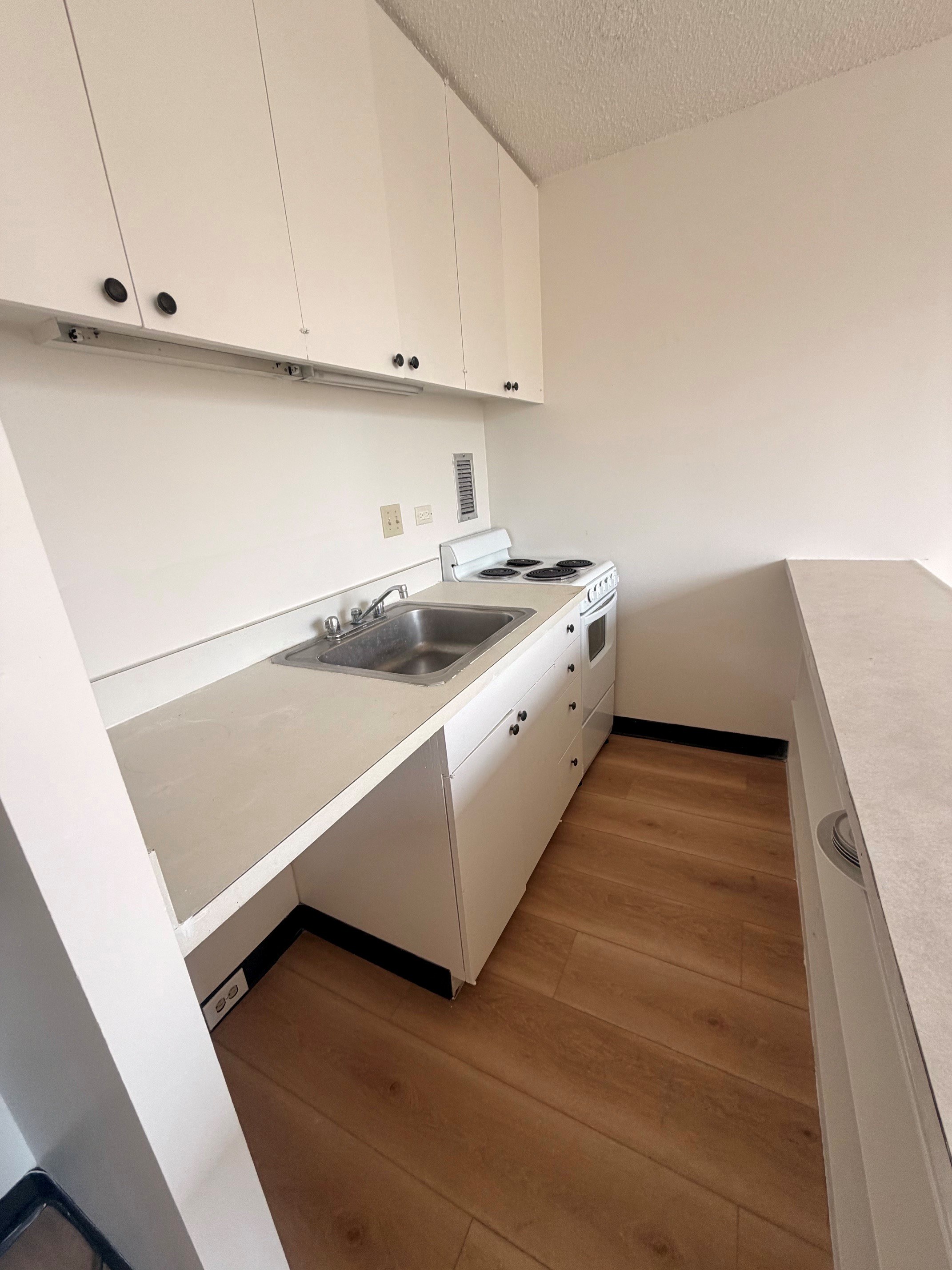 A kitchen with white cabinets and a sink.